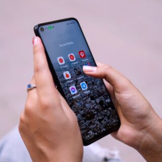 ソーシャルメディアアプリが表示されているスマートフォンを触っている